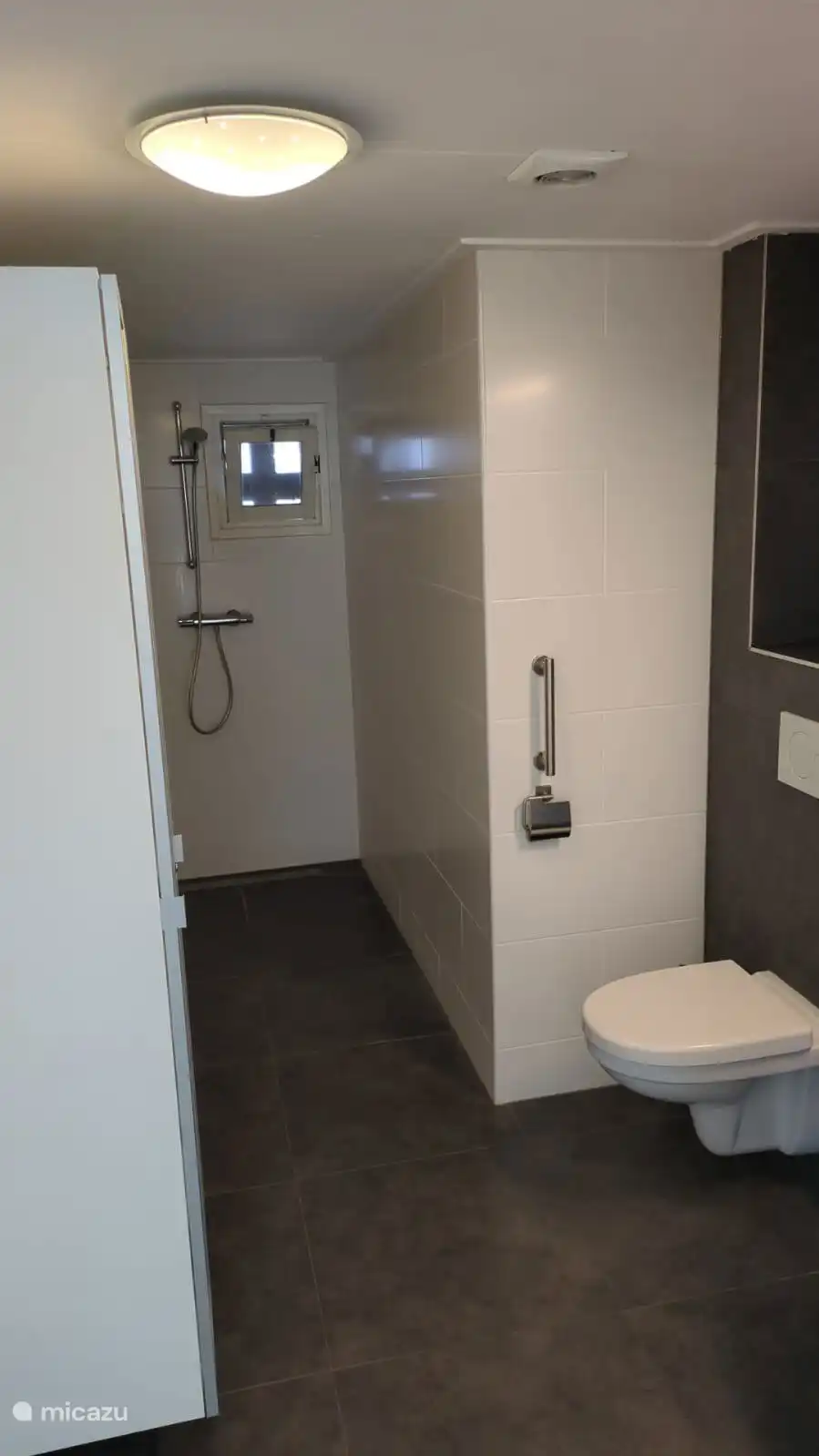 Badezimmer mit begehbarer Dusche, WC, Waschbecken und Schränken