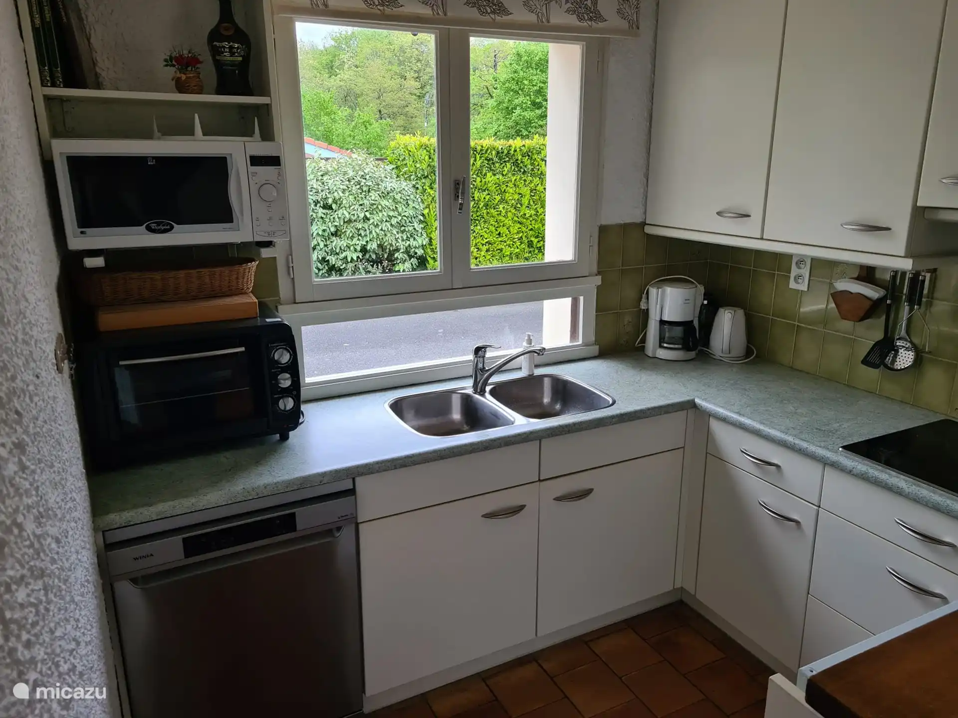 Küche mit Geschirrspüler, Backofen und Mikrowelle