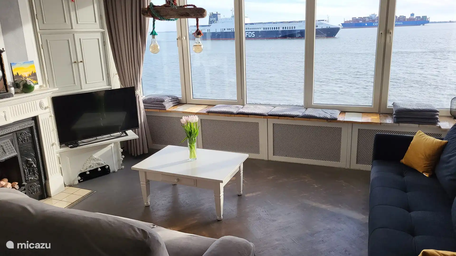 Wohnzimmer 1 mit 2 geräumigen Sofas. Die breite Fensterbank (5 Meter) kann auch als Sitzbank genutzt werden. Es sind ausreichend Kissen vorhanden.