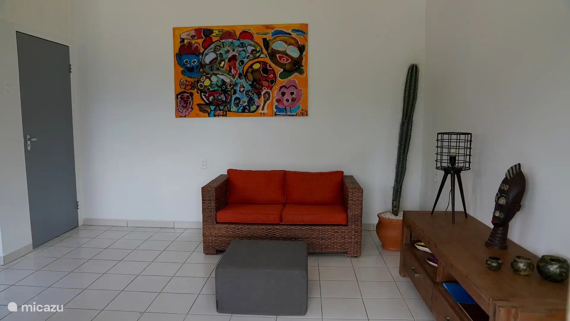 Geräumiges Wohnzimmer mit Schlafsofa und Blick auf die private Terrasse.