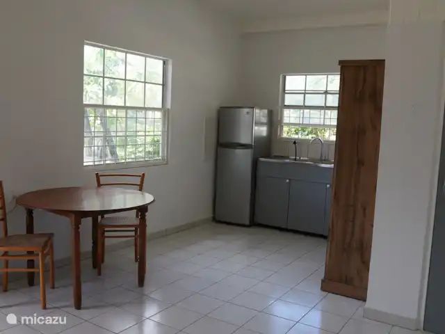 Apartamento Domenica - Aquila en Curazao, Curazao Centro, Santa Rosa-Scherpenheuvel - apartamento Cocina con frigorífico, congelador, cocina a gas, horno, hervidor de agua, aire acondicionado, ventilador y nevera portátil y mesa de comedor para dos personas.