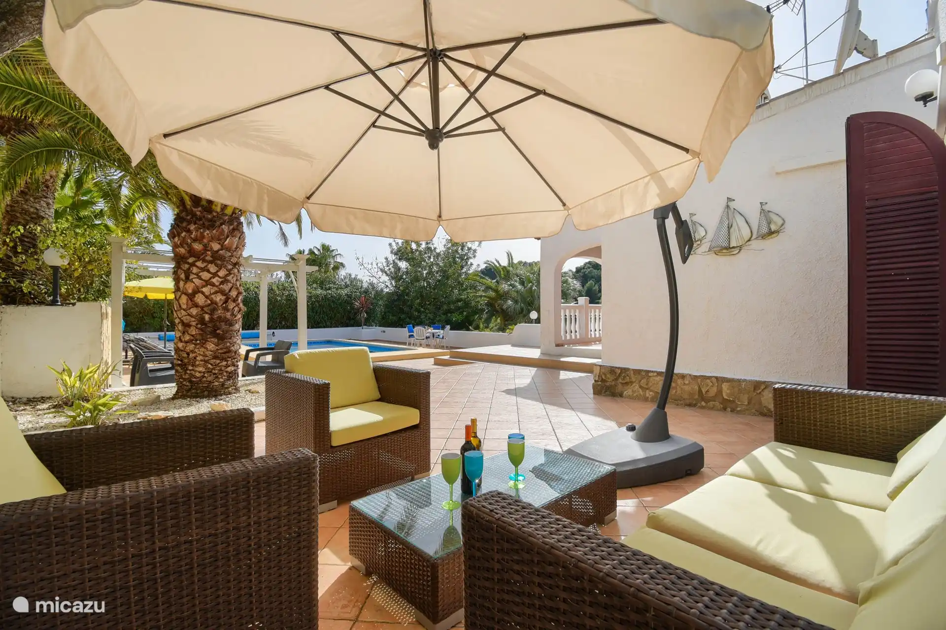 Lounge-Sitzecke, Sofa, Stühle und ein schwimmender Sonnenschirm