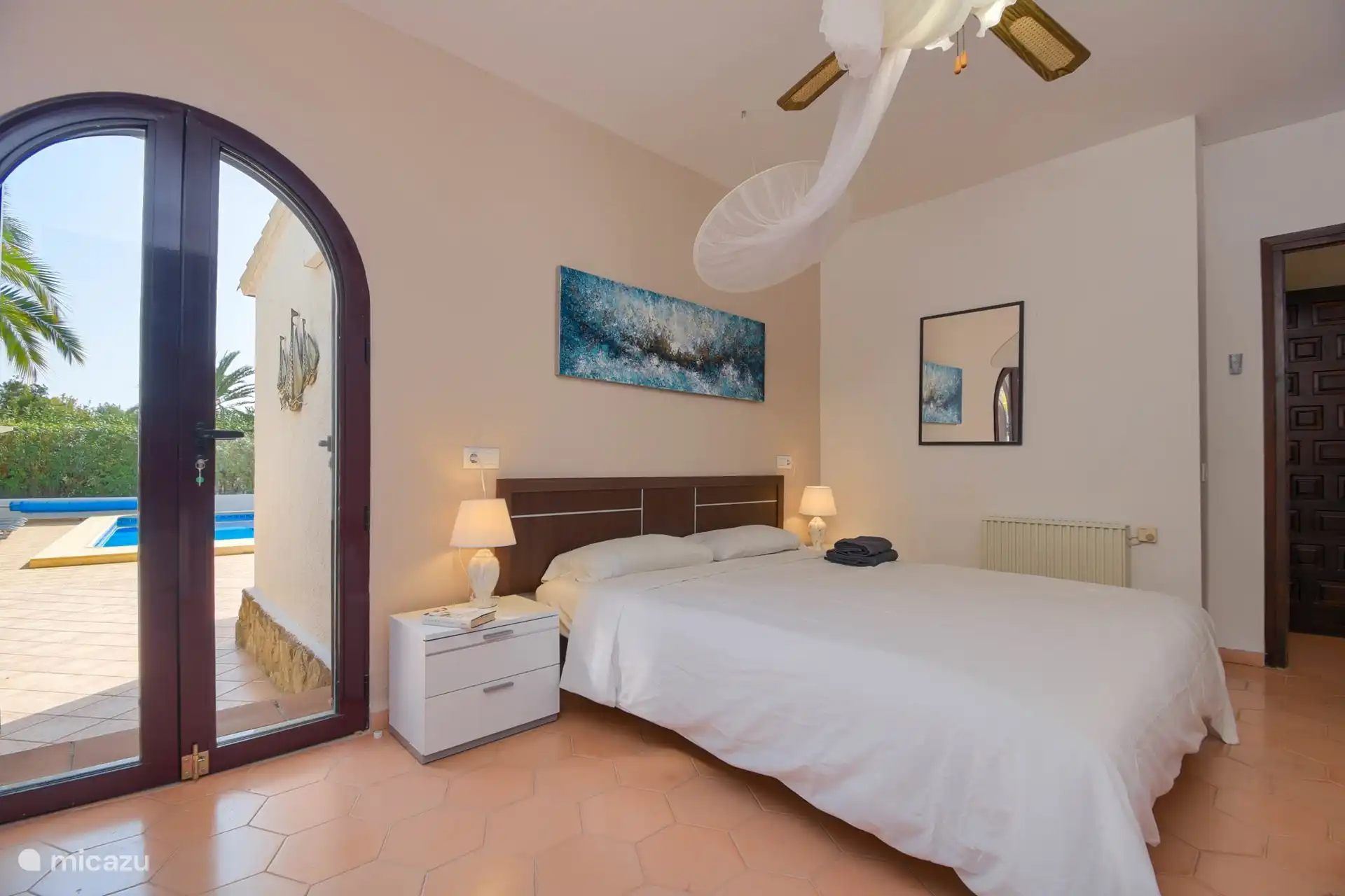 Hauptschlafzimmer mit einer guten Matratze mit Topper und Bad en-suite; Fenstertüren zum Poolbereich.