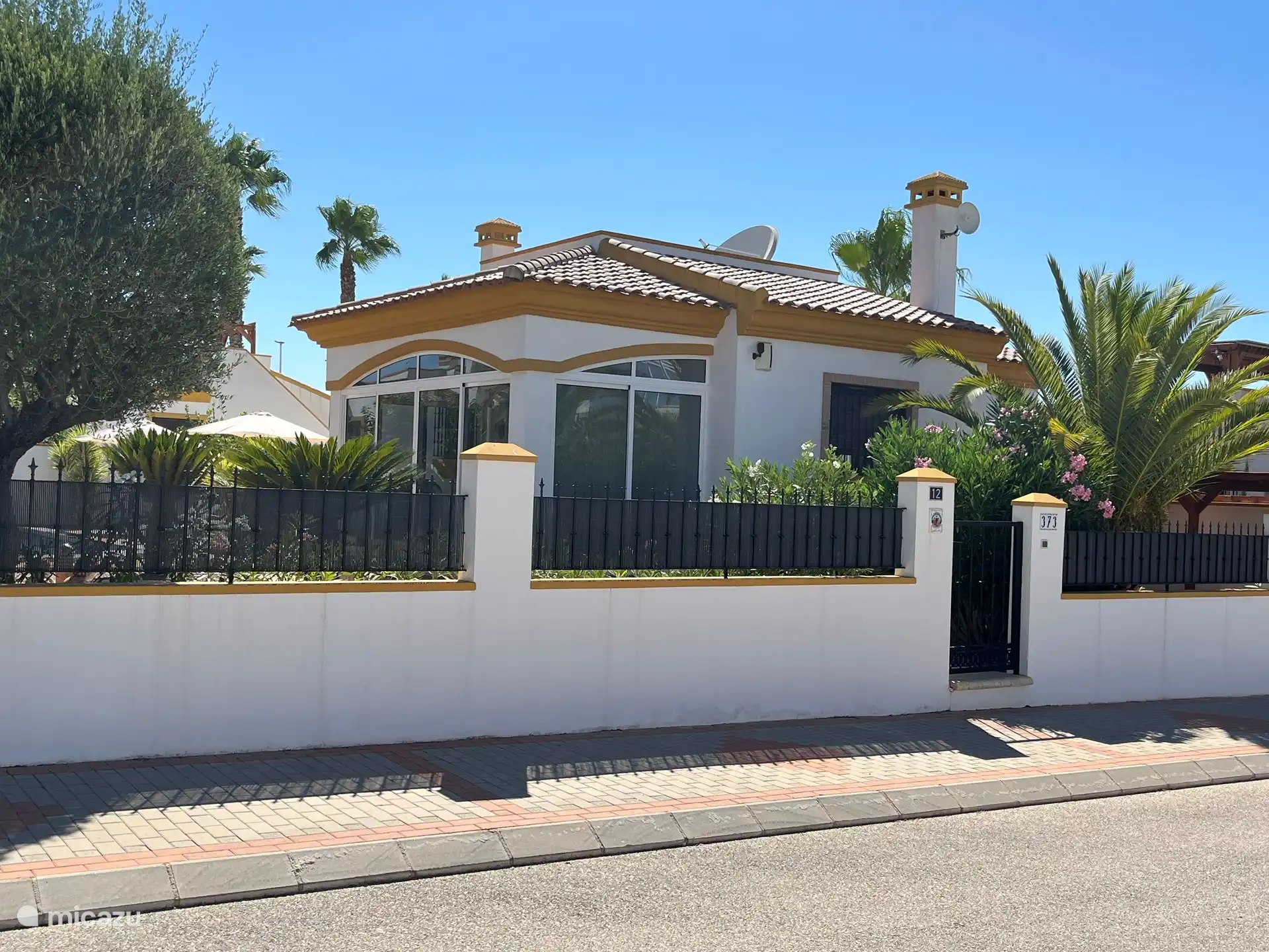 Front view of Casa Jeta. A spacious street, with more than enough parking. A spacious sidewalk on both sides of the road. Perfect for taking a walk around the neighborhood.
You can just see the private parking lot.
