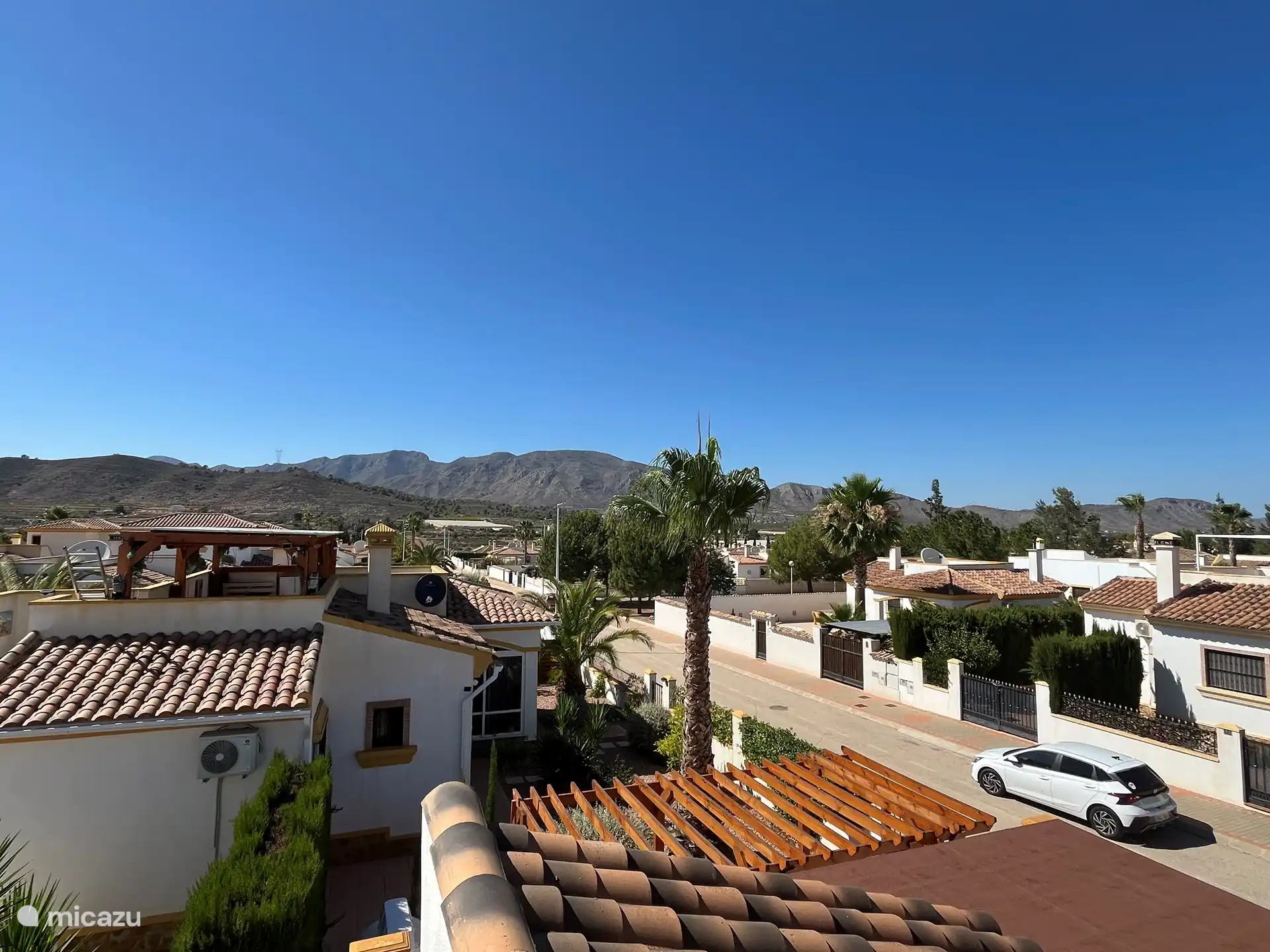 View from the roof terrace over the mountains.
You can see that the street is quiet. Halfway there is a small square with playground equipment for the young children.