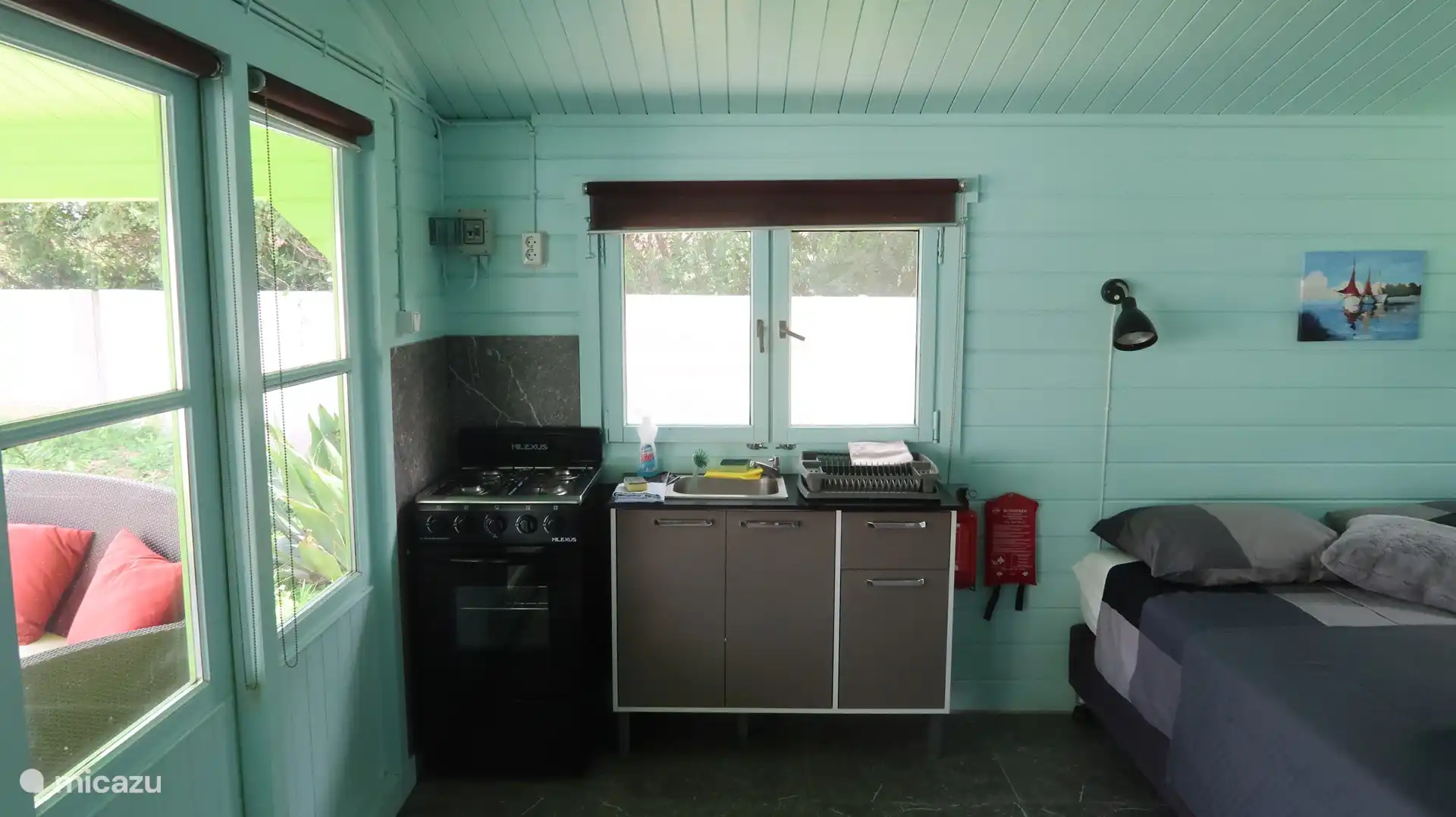 Küche mit Esstisch, Kühlschrank, Wasserkocher, Herd und Backofen. Grillen