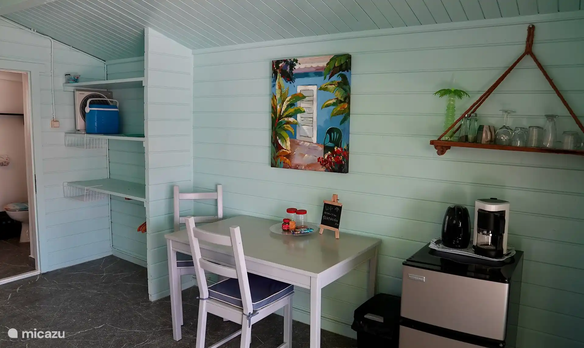 Küche mit Esstisch, Kühlschrank, Wasserkocher, Herd und Backofen. Grillen