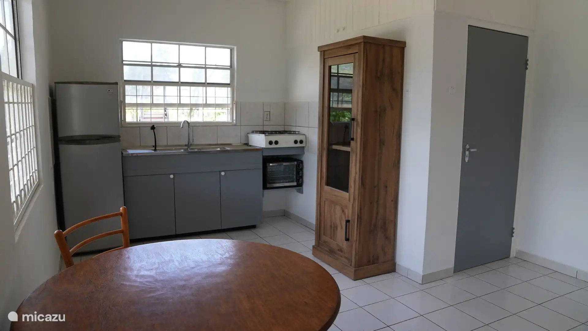 Küche mit Kühlschrank, Gefrierschrank, Gasherd, Backofen, Wasserkocher, Klimaanlage, Ventilator und Kühlbox