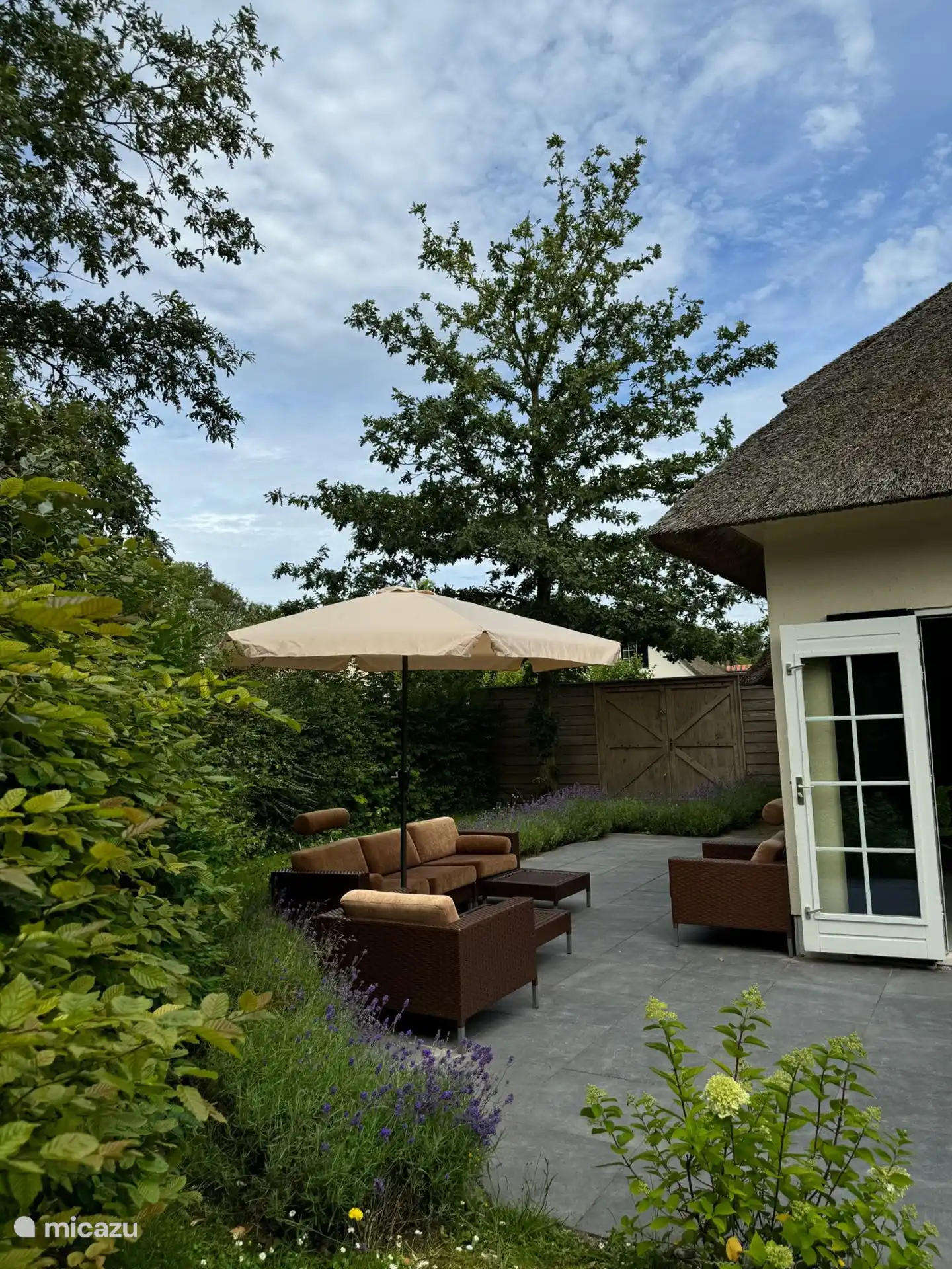 Terrasse mit Lounge-Set und Sonnenschirm