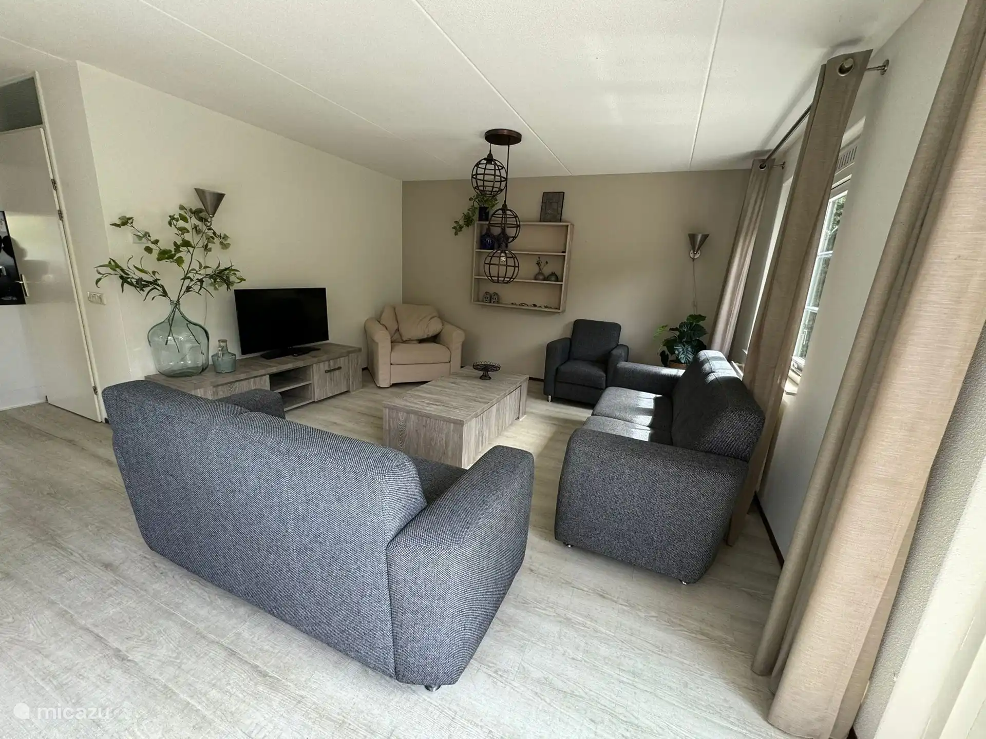 Wohnzimmer mit 2 Sofas, 2 Stühlen und TV