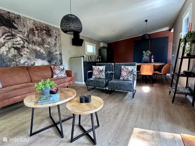 Maison de la Nature Dennenzicht - @Veluwe | Pays-Bas, Gueldre, Wells - chalet Le salon dispose d’une luxueuse cuisine ouverte et est meublé d’un joli canapé, de deux fauteuils luxueux et d’une télévision. Le chalet dispose d’un chauffage au sol et de la climatisation pour les chaudes journées d’été.