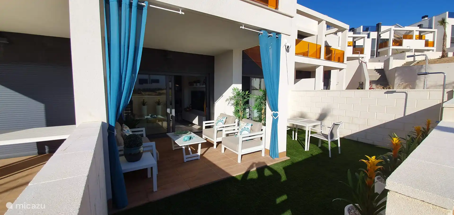 Segundo jardín adyacente a la gran piscina con ducha privada, salón y mesa de comedor para hasta seis personas