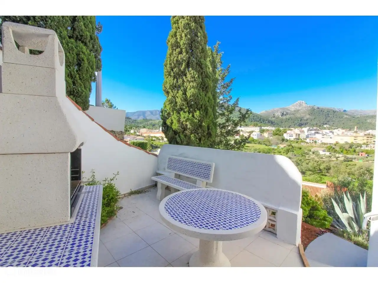 An der Seite des Hauses befindet sich eine zus&#228;tzliche Terrasse mit typisch spanischen Mosaik-Gartenm&#246;beln. Hier k&#246;nnen Sie bei starker Brise gesch&#252;tzt sitzen.