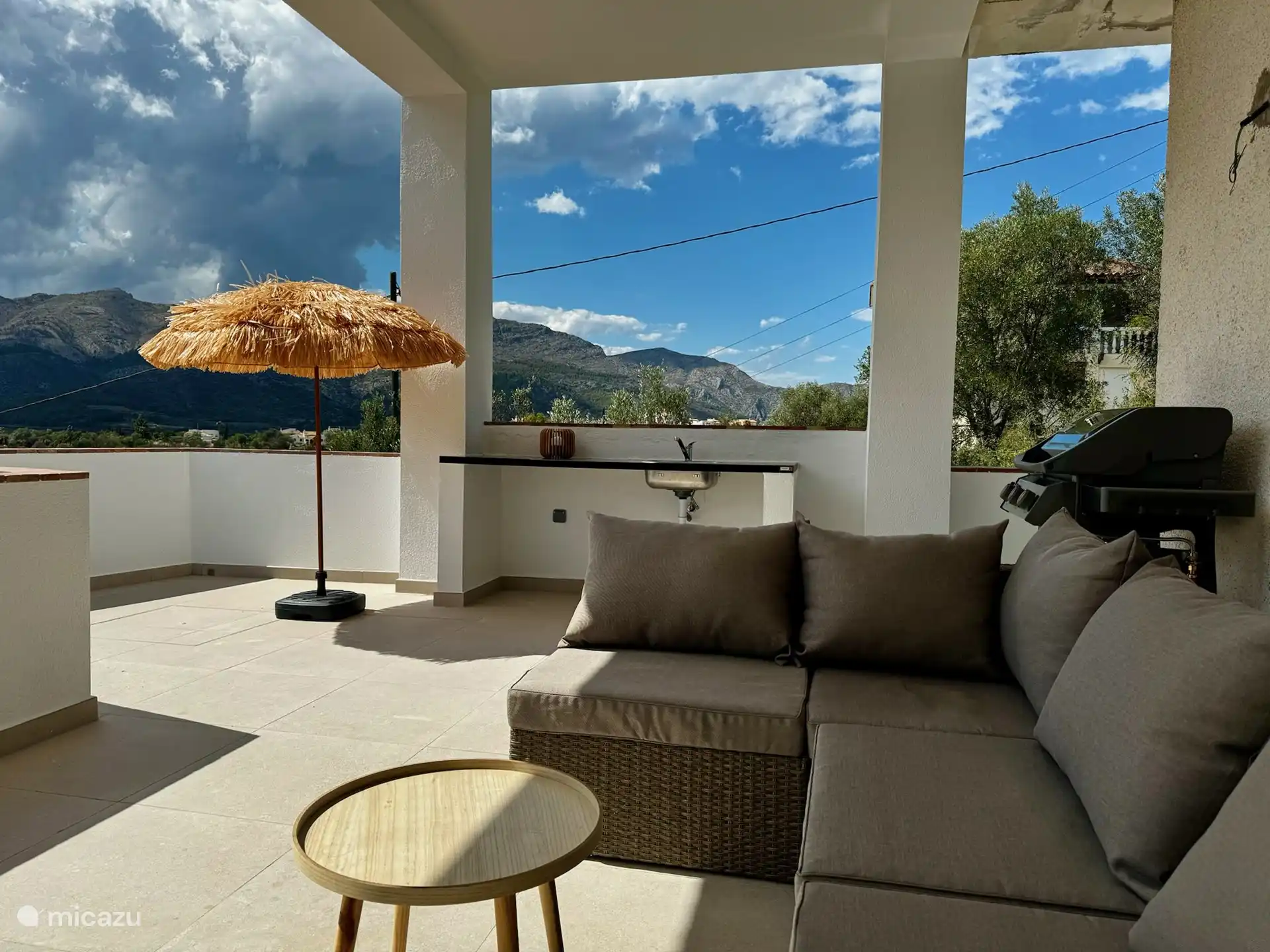 Im Erdgeschoss befindet sich ein gro&#223;er &#252;berdachter Balkon mit Esstisch, Lounge-Sofa und Au&#223;enk&#252;che. Dort kann man im Schatten sitzen, wenn es zu hei&#223; wird.