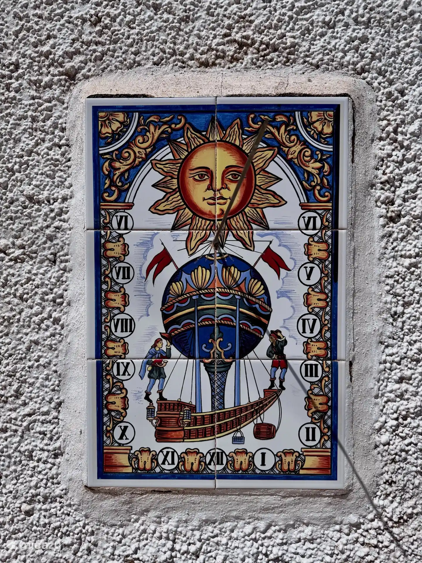 An der Au&#223;enwand h&#228;ngt eine typisch spanische Sonnenuhr.