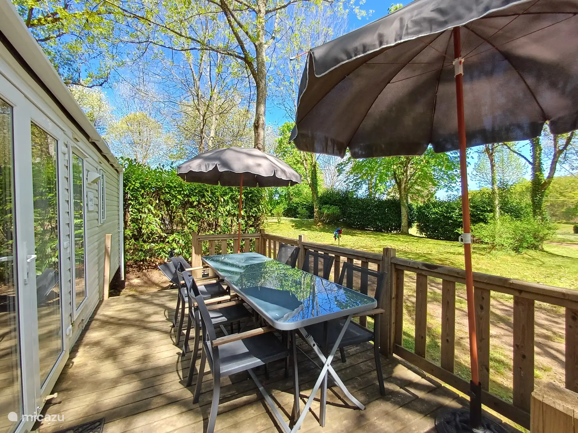 Terras aan de Mobil Home met tafels en parasols