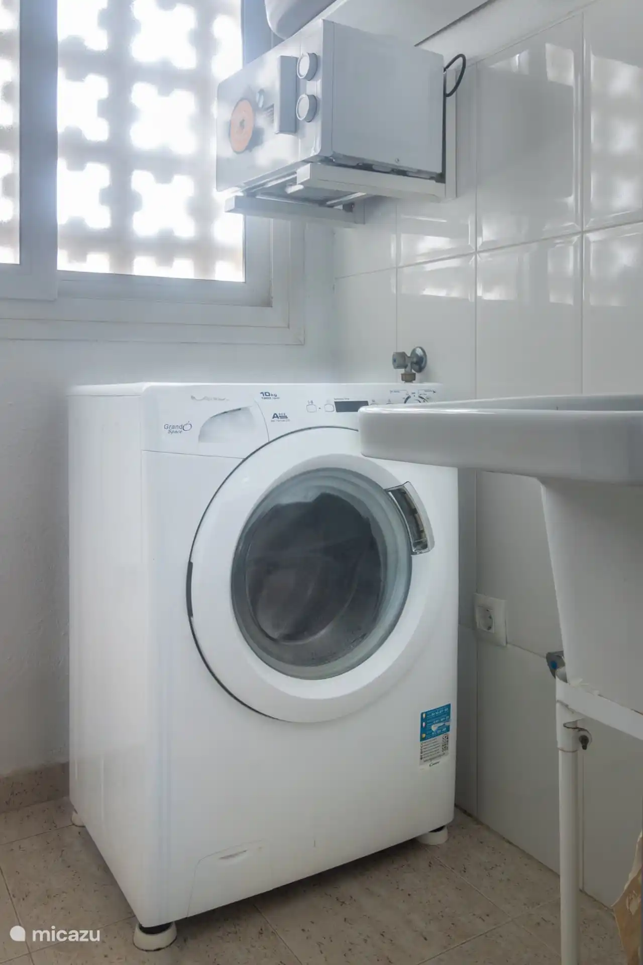 grote spoelbak, wasmachine en magnetron in bijkeuken