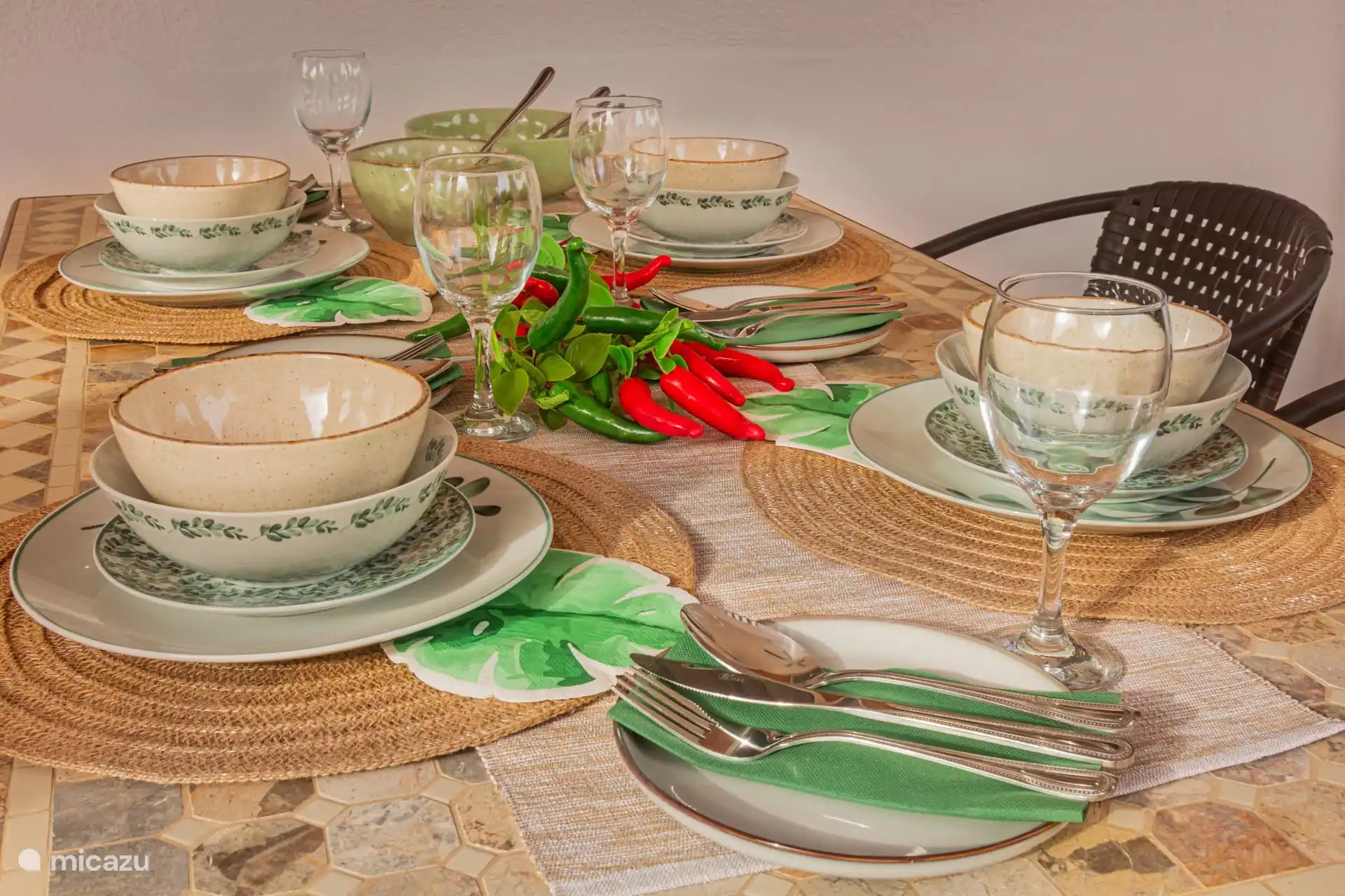 overdekt terras met eettafel, stoelen en serviesgoed