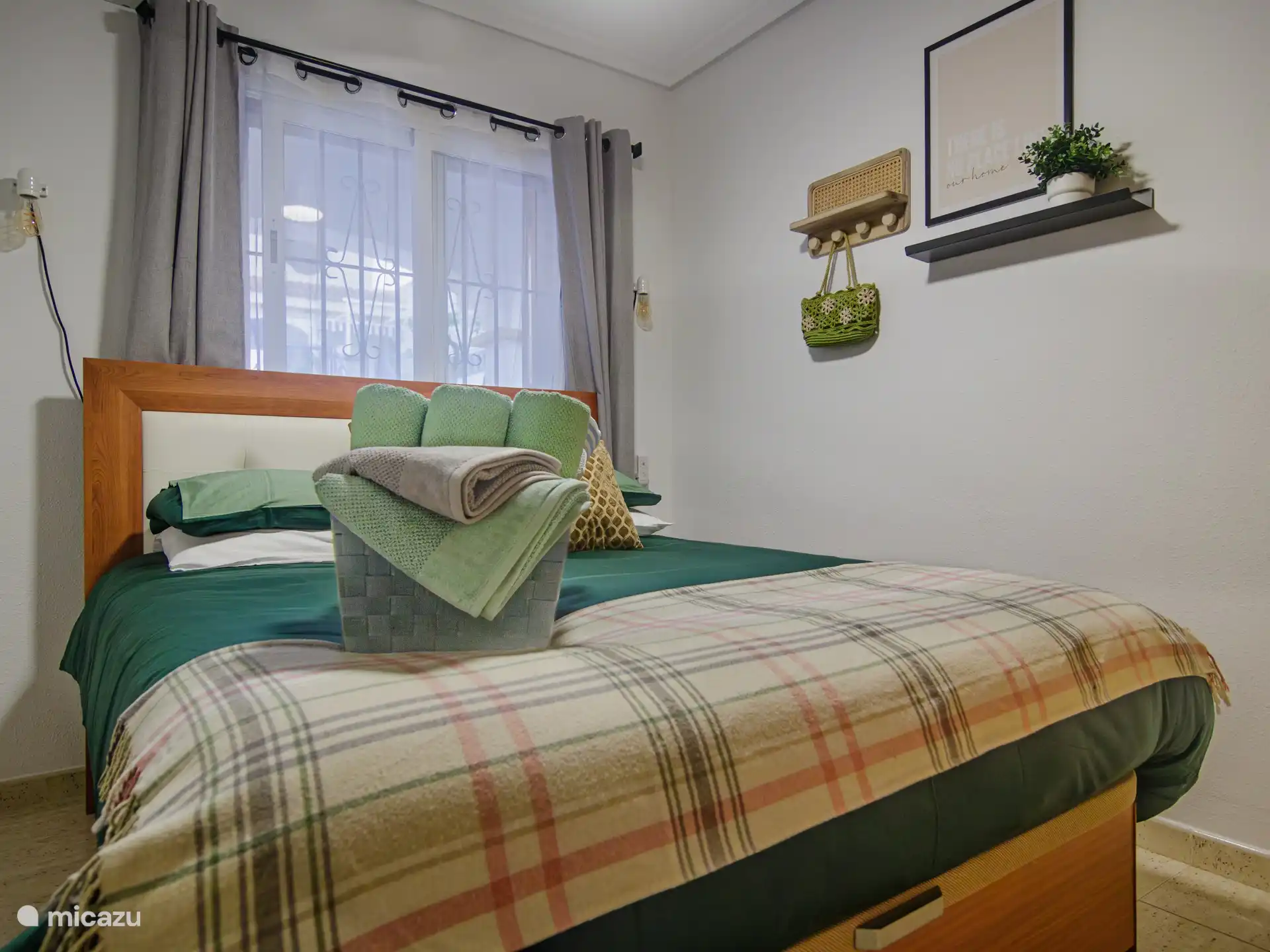 tweede slaapkamer met bed met kwaliteitslinnen, handdoeken, sierkussen en moderne decoratie