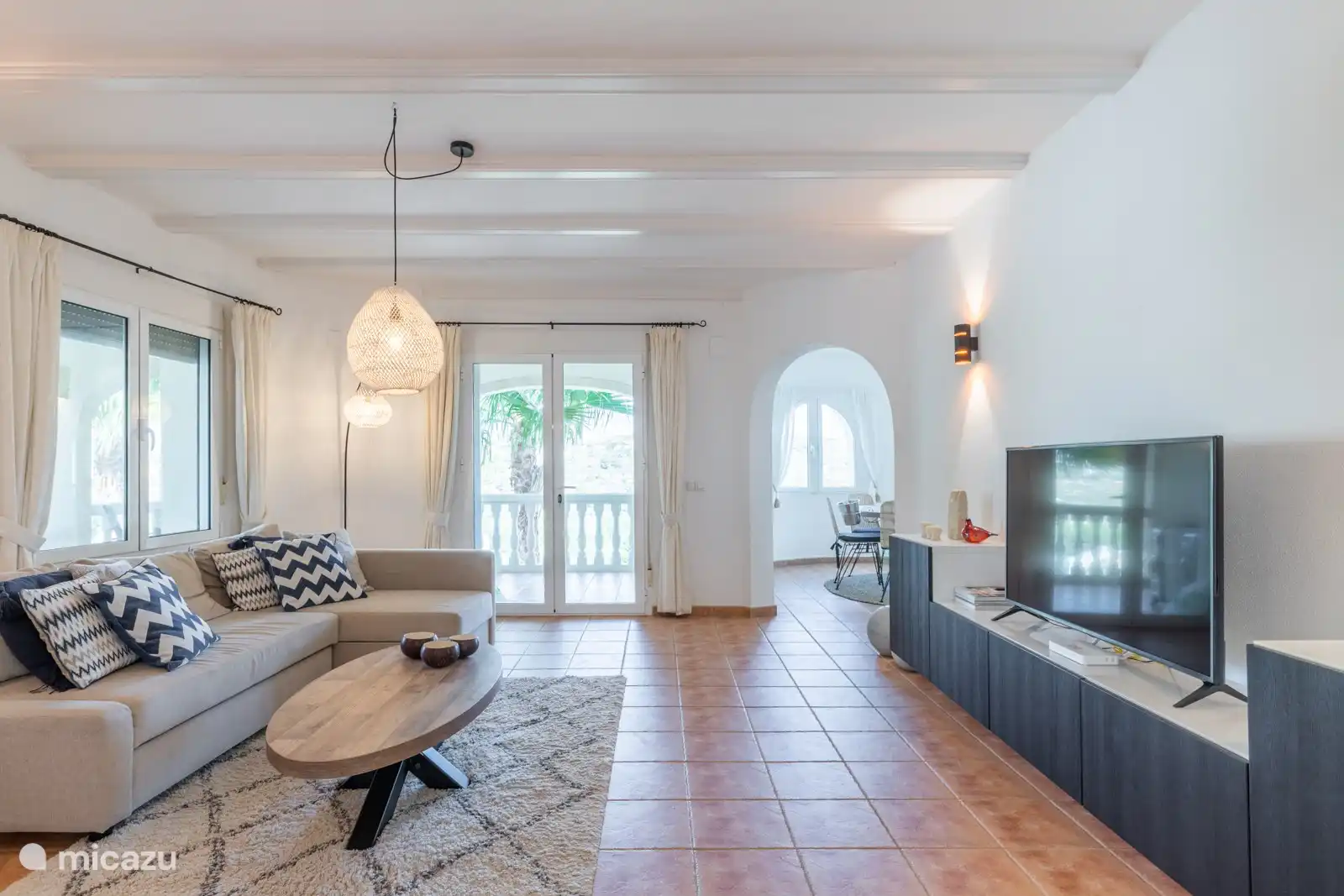 Wohnzimmer mit offenen Türen zur überdachten Terrasse und schöner Aussicht