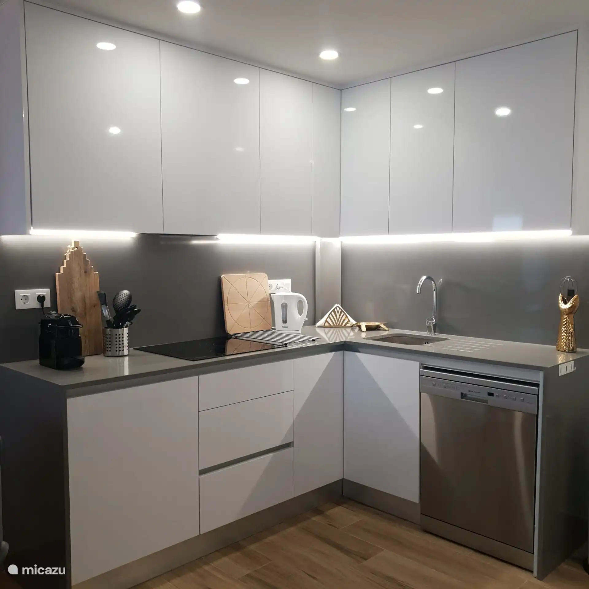 Teil der Küche. Diese ist mit einem Geschirrspüler, einem Backofen, einem Cerankochfeld, einem Kühlschrank mit Gefrierfach und einer Mikrowelle ausgestattet. Außerdem gibt es eine Nespresso-Kaffeemaschine, einen Wasserkocher, eine Saftpresse und einen Toaster. Es ist also alles vorhanden, um ein leckeres Essen zuzubereiten.