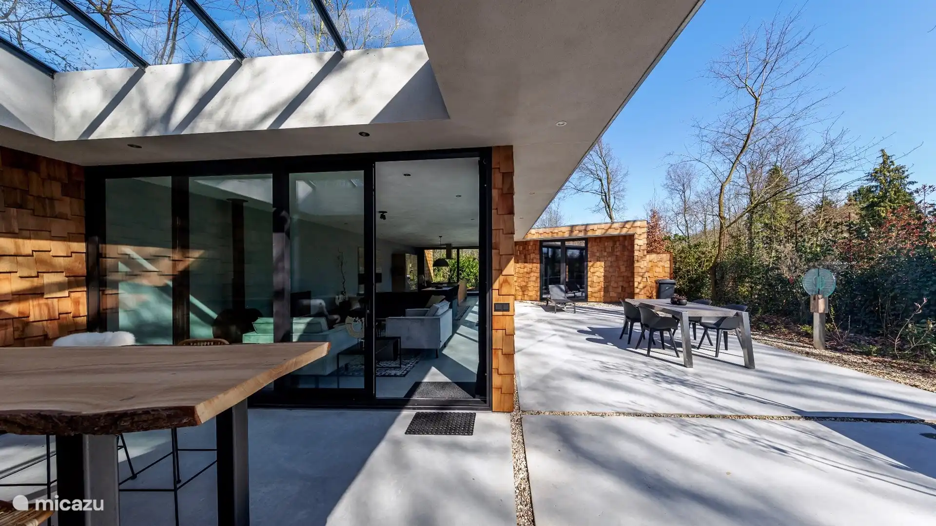 Teilweise überdachte Terrasse mit hohem Getränketisch 