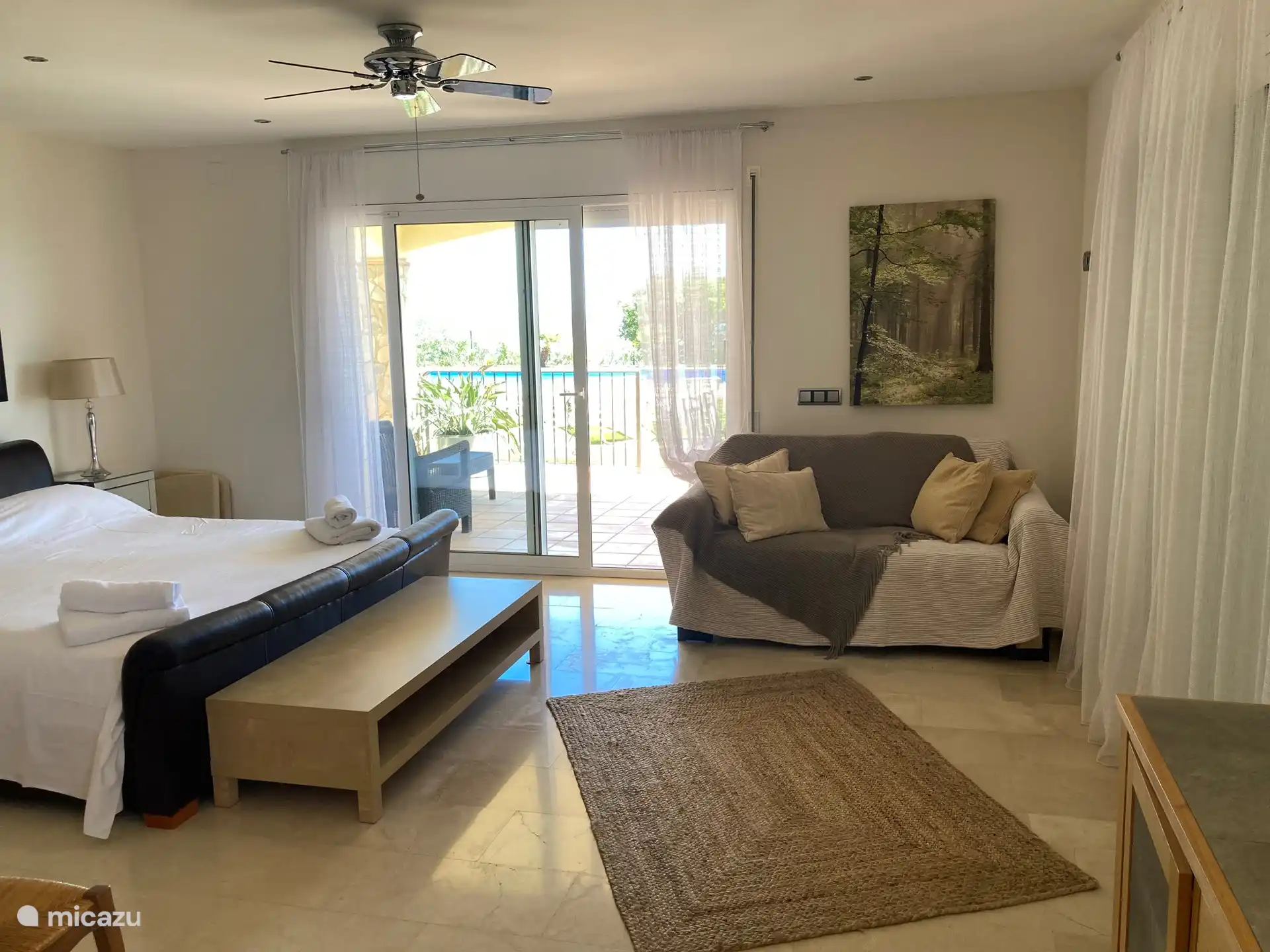 Hauptschlafzimmer mit Schiebetüren zur Außenterrasse und zum Swimmingpool