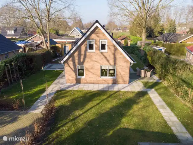 Cabaña en el bosque 38 en Países Bajos, Overijssel, Den Ham - casa vacacional Una foto general del jardín. El asiento a la izquierda de la casa ahora está equipado con una mesa con 6 sillas. En la parte inferior derecha se puede ver una pequeña parte del 3er asiento.