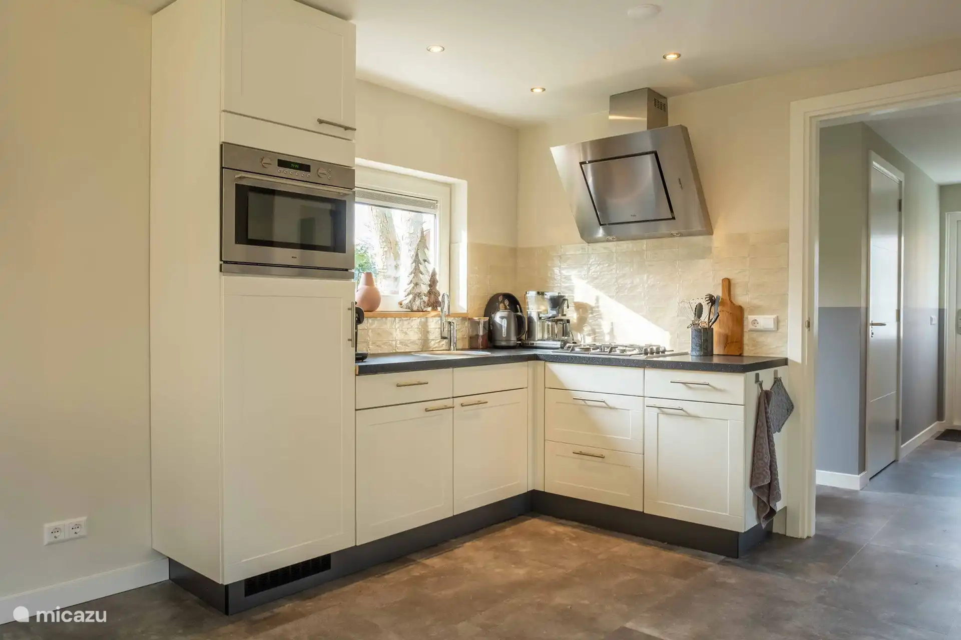 Die Küche ist mit einer Kombi-Mikrowelle, einem Kühlschrank mit Gefrierfach und einem Geschirrspüler ausgestattet. 