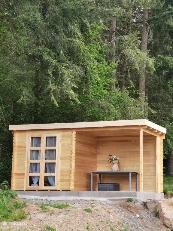 Cabaña de jardín con zona de estar cubierta