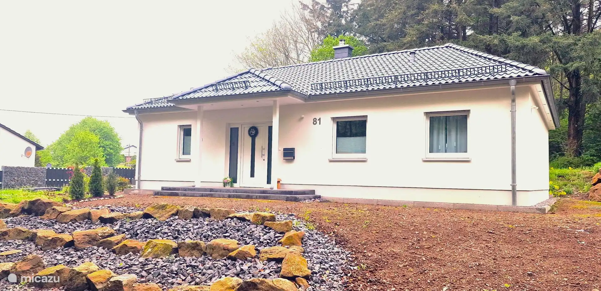La vista del edificio desde el frente muestra la casa de planta baja de nueva construcción con una explanada aún en construcción.