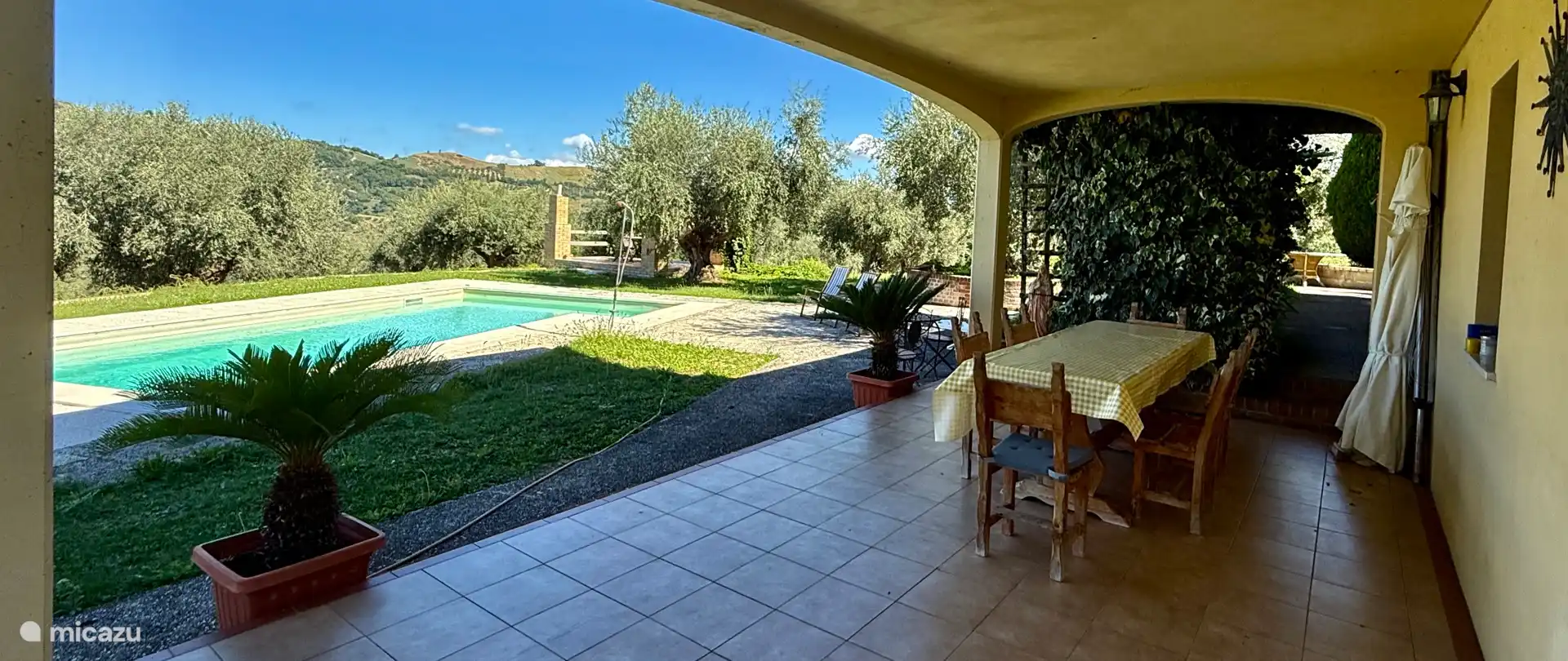 Desde el pórtico vista de piscina, pérgola y huerto privado.