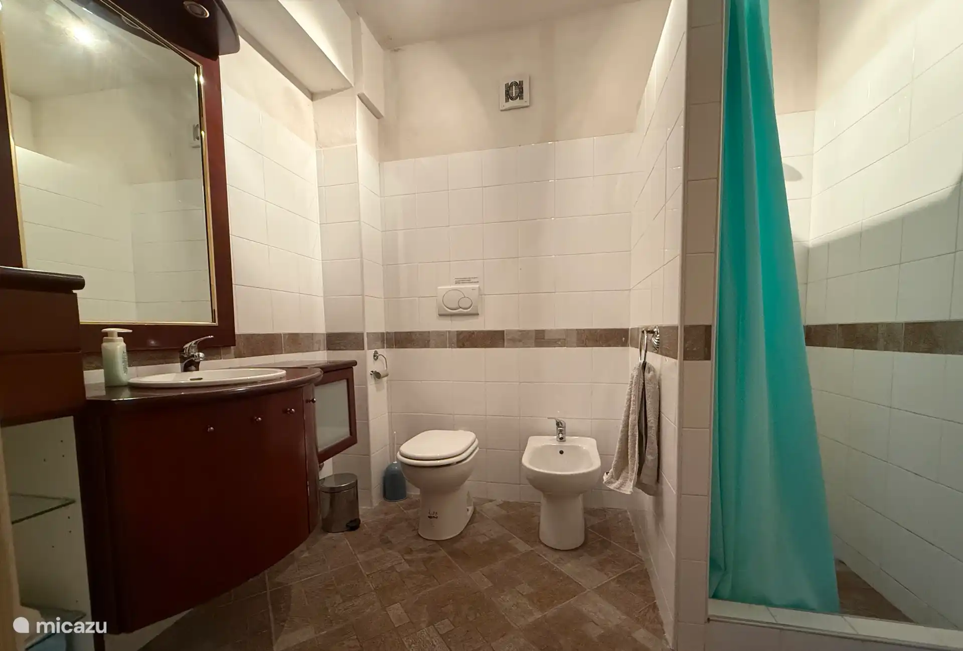 Baño con extractor, inodoro, bidé, lavabo y ducha.