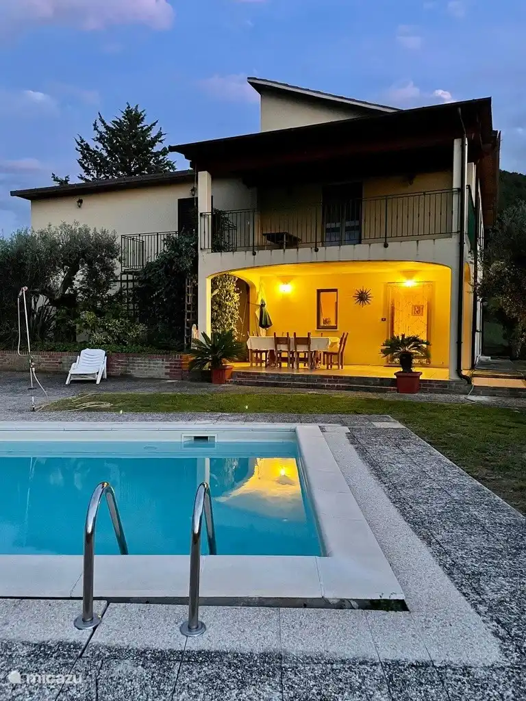 Desde la piscina vista al pórtico con mesa de comedor para 6 personas. 