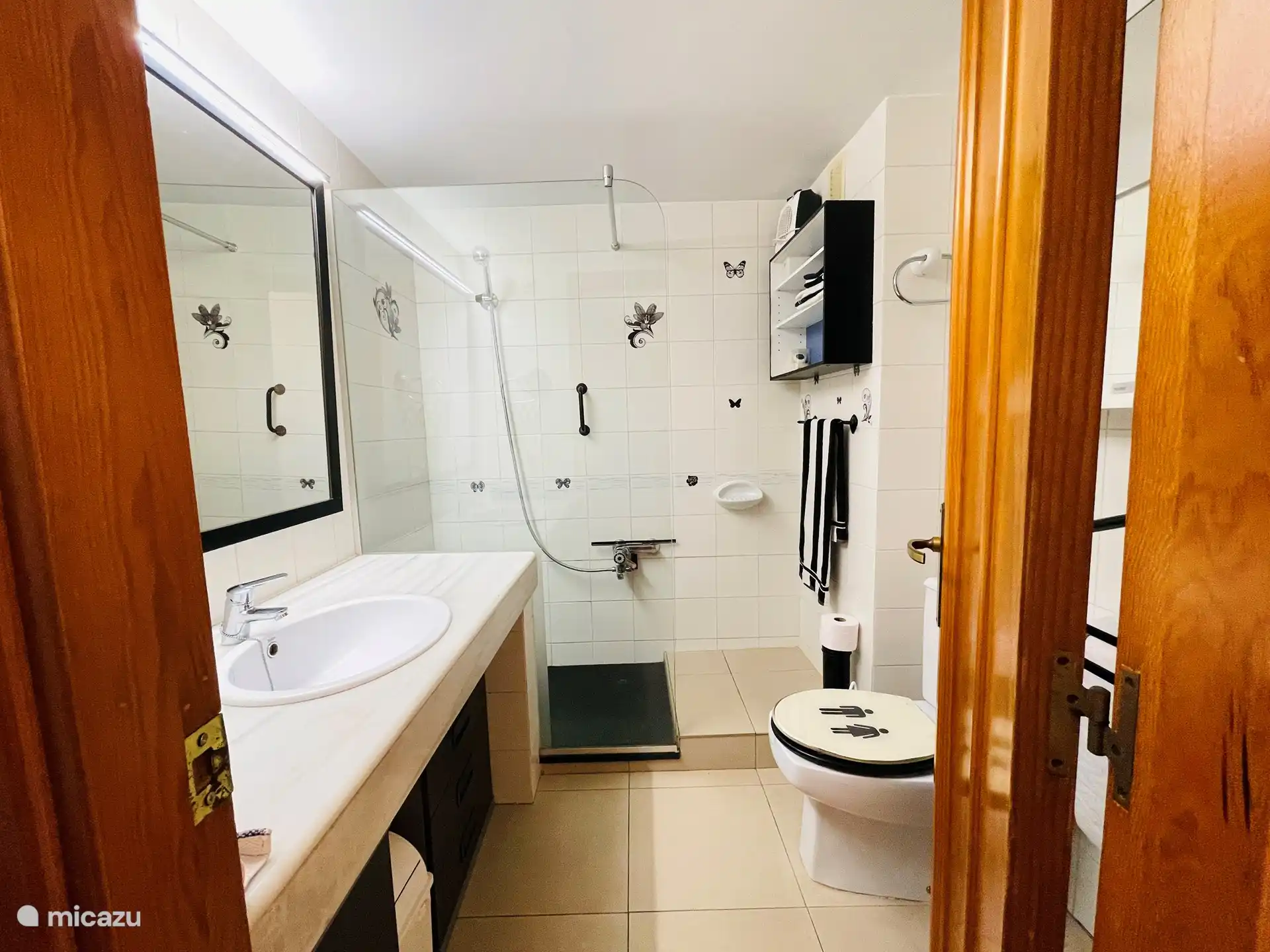 Salle de bain avec douche à l’italienne, WC et lavabo.