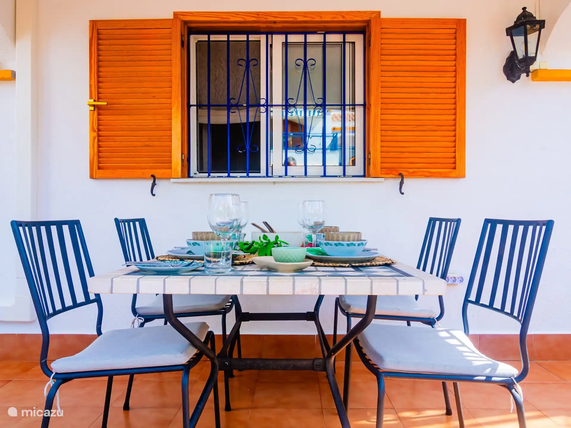 Eettafel buiten onder het overdekte terras met ventilator. 