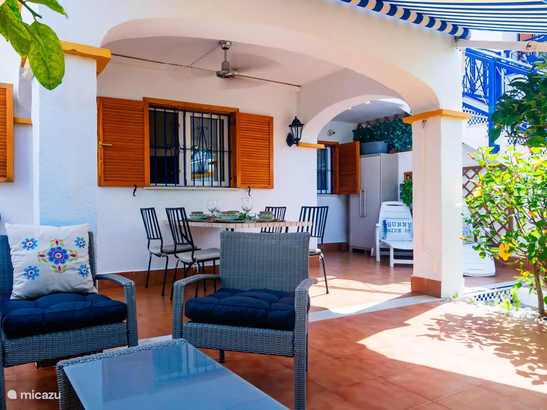 lounge set, eettafel buiten onder het overdekte terras met ventilator. 