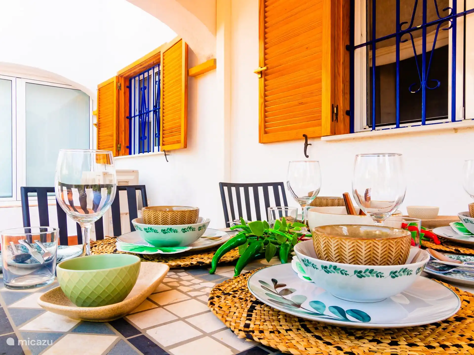 Eettafel buiten onder het overdekte terras met ventilator. 