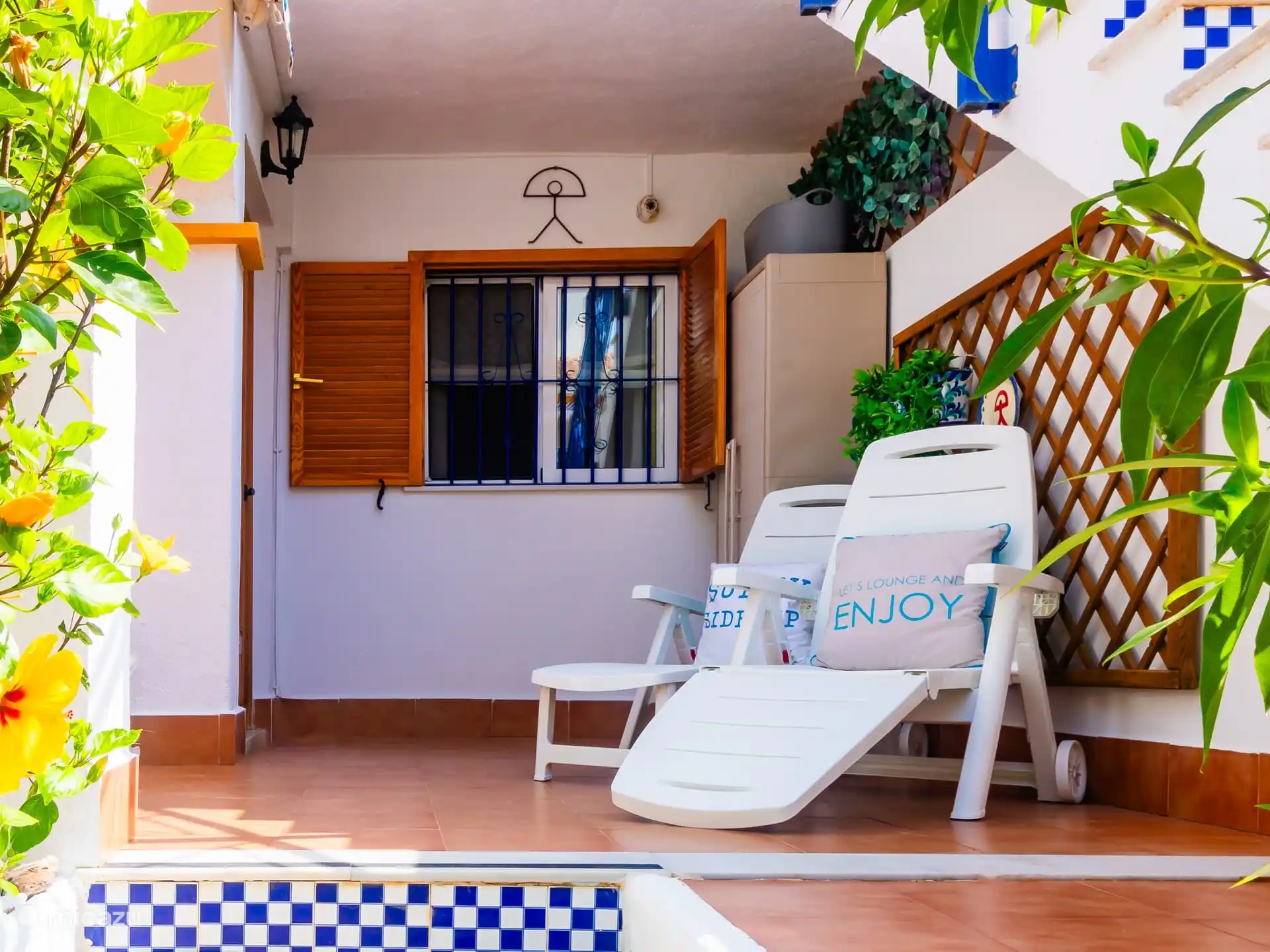 Terras met zonnebedden. 
