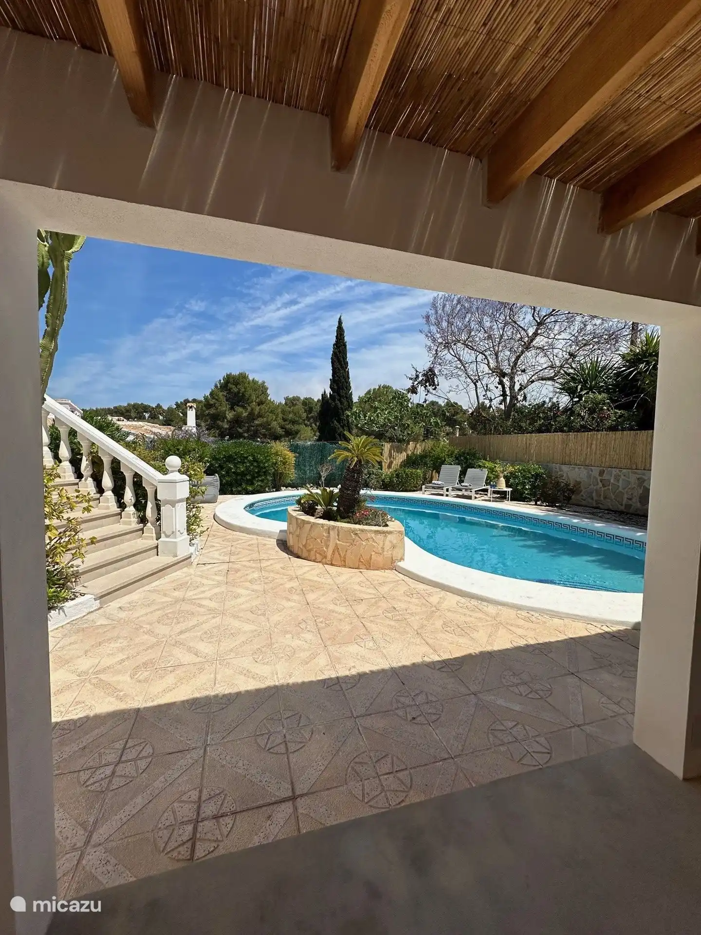 De tuin is heerlijk beschut waardoor je in alle rust kunt zonnen.