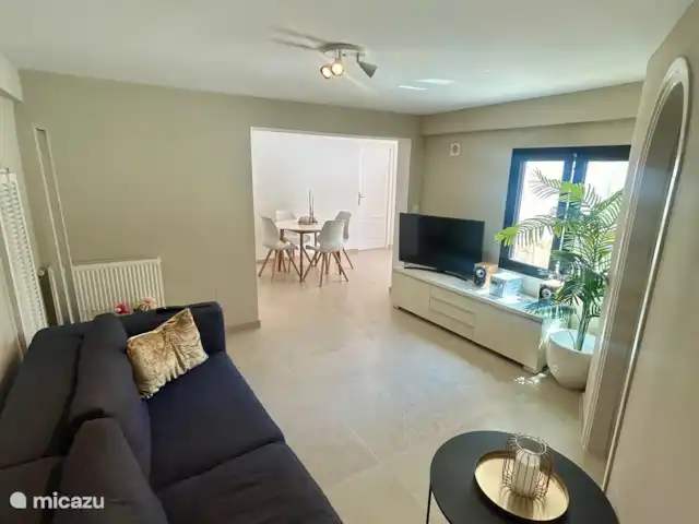 Appartement avec piscine à Casa Naranja | Espagne, Costa Blanca, Jávea - appartement Le salon avec vue sur la piscine et TV avec toutes les chaînes néerlandaises.