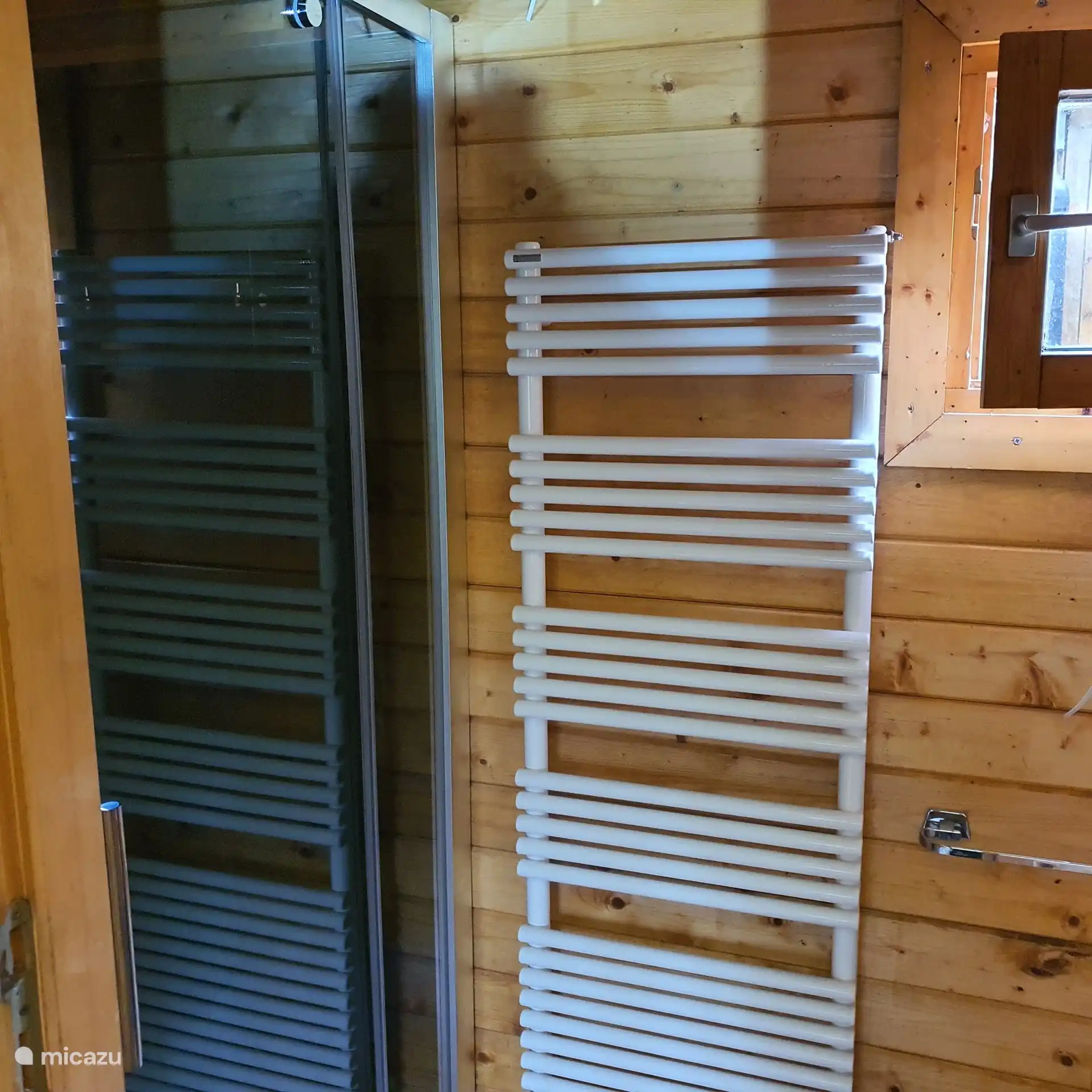 Baño con la ducha a la izquierda, el inodoro seco a la derecha.