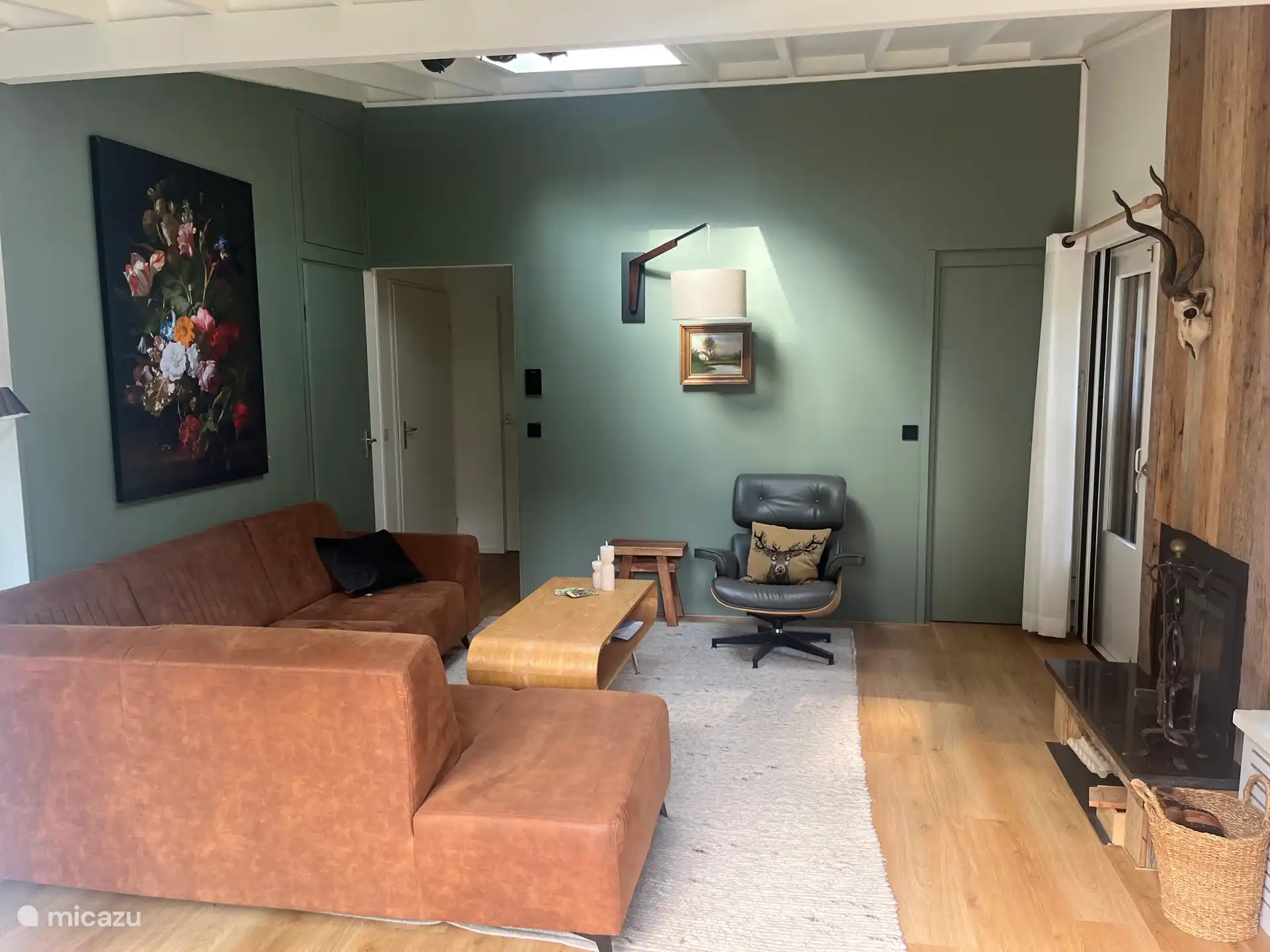 In de woonkamer staat een hoekbank en een emes stoel. Lekker met gezin bij de haard (met een nep-gewei)  of TV kijken