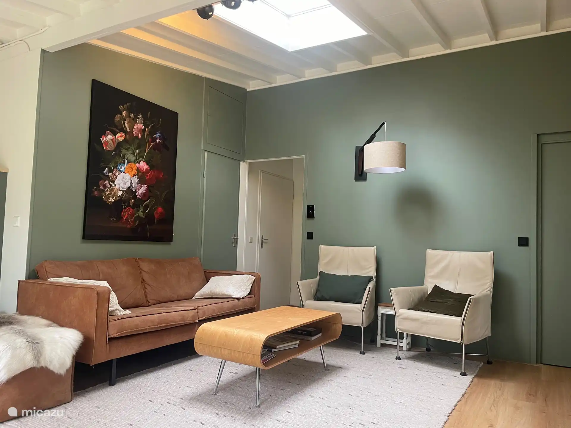 Woonkamer heeft een 2,5 zit bank, 2 stoelen, eem ronde lounge stoel en TV