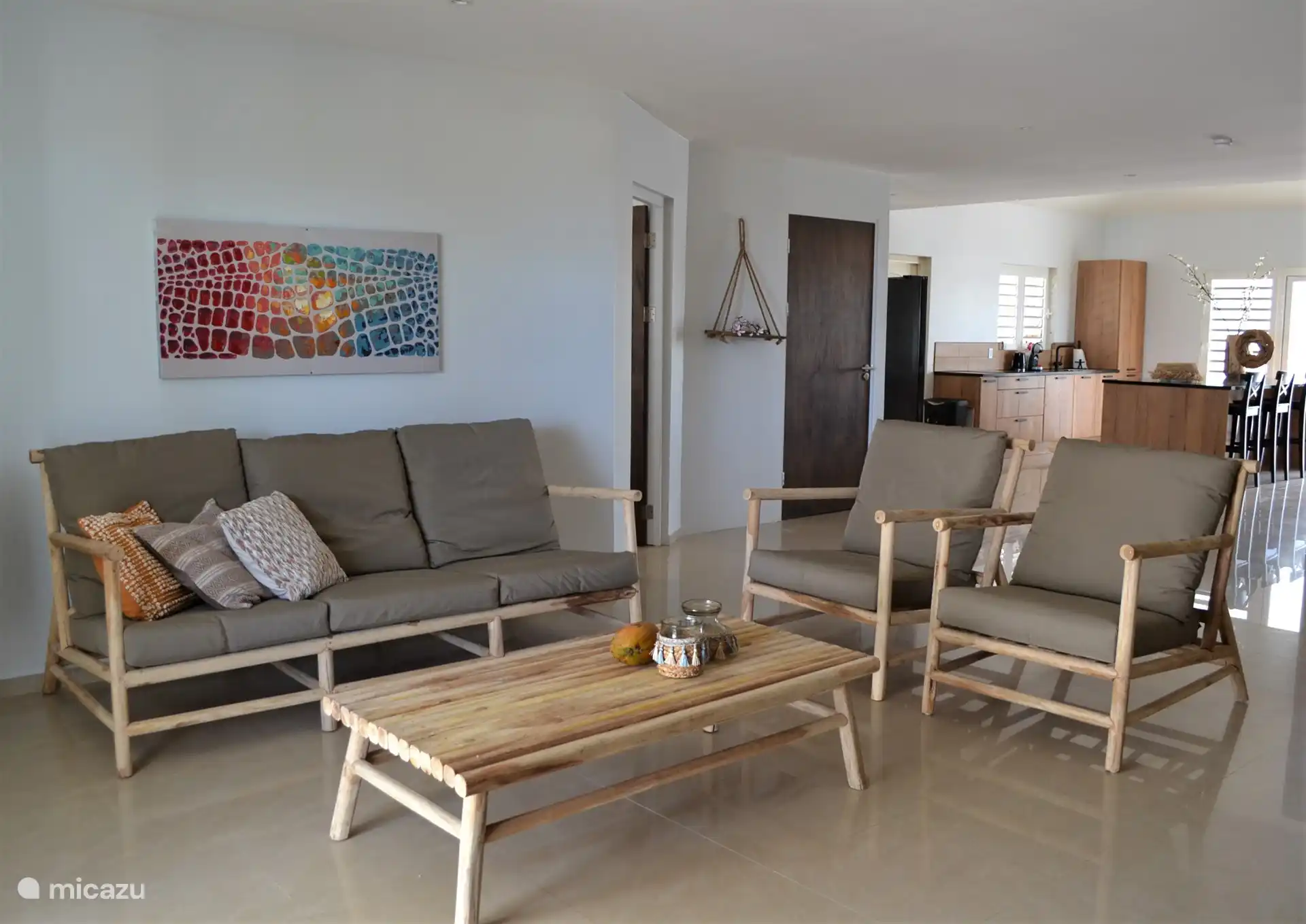 Wohnzimmer mit Sofa, zwei Sesseln und TV.