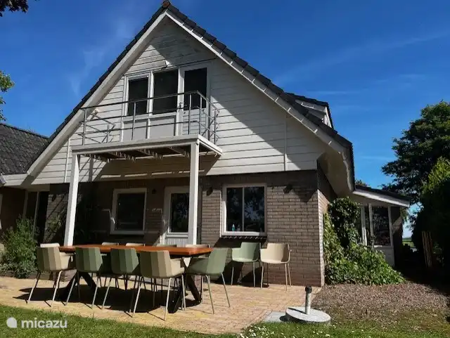 Vorderseite des Hauses mit geräumigem Tisch und 10 Stühlen