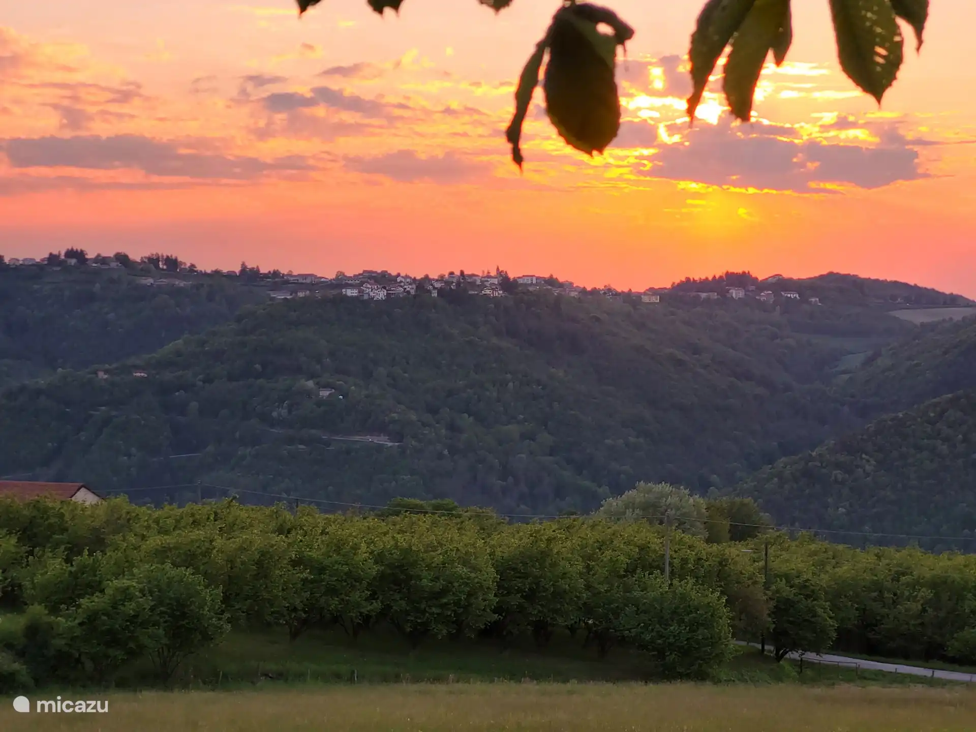 Blick von der Terrasse unter dem Kastanienbaum auf Bossolasco bei Sonnenuntergang.