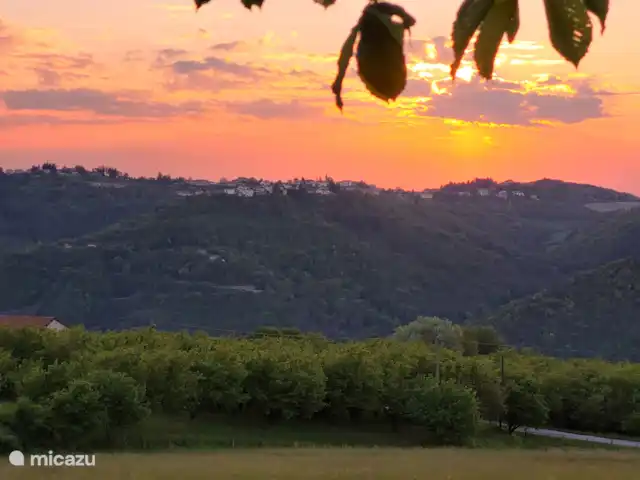 Location de Vacances Italie, Piémont, Niella Belbo, maison de vacances - Casa Rocco  Vue de la terrasse sous le châtaignier sur Bossolasco au coucher du soleil.