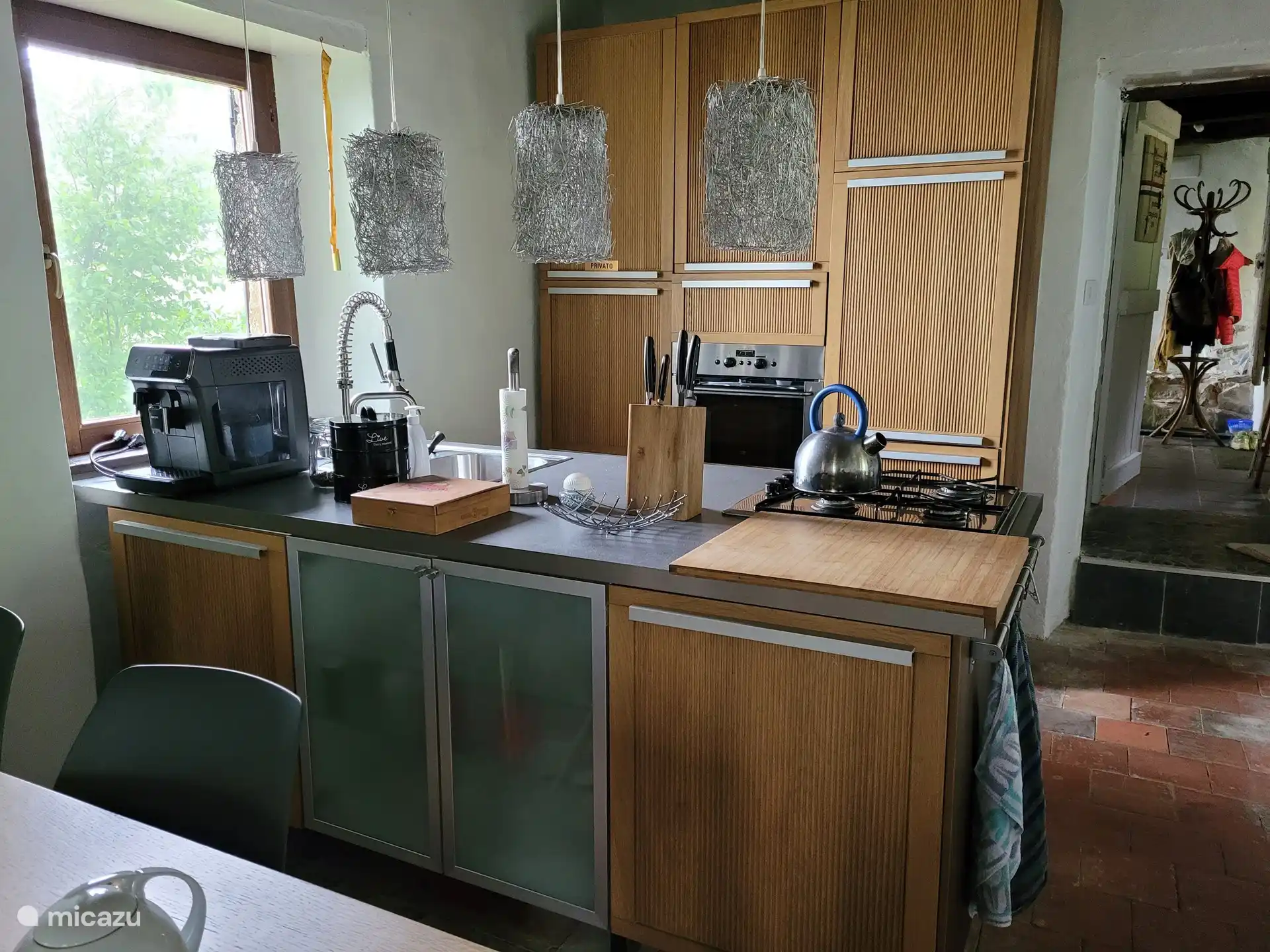 Küche mit Backofen, Kühlschrank mit Gefrierfach, Geschirrspüler und Kaffeemaschine.