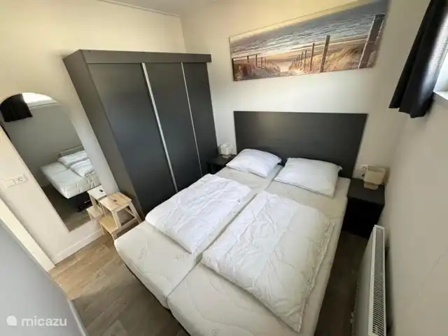 chalet huren in Nederland, Texel, Den Burg – Chalet Zeebries Slaapkamer 1 met 2-persoons boxspring, 3-delige kledingkast en spiegel.
